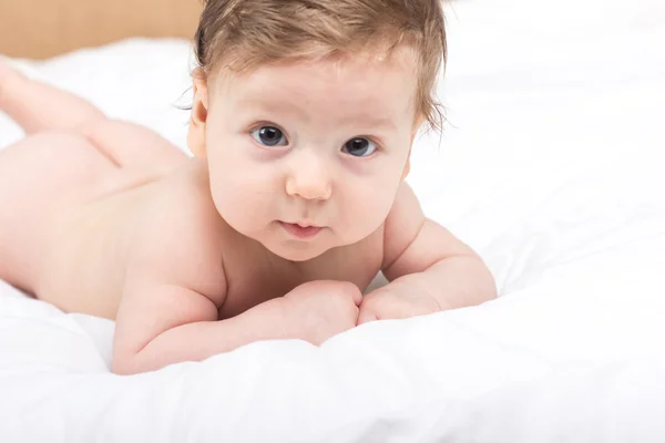 Portrait of a naked child. A child on a white bed. Handsome boy. smiling child — Stock Photo, Image