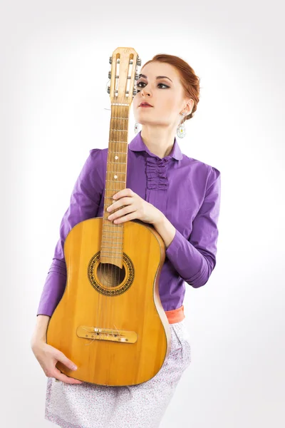 Joven pelirroja sosteniendo una guitarra sobre un fondo blanco. Retrato de una chica con una guitarra —  Fotos de Stock