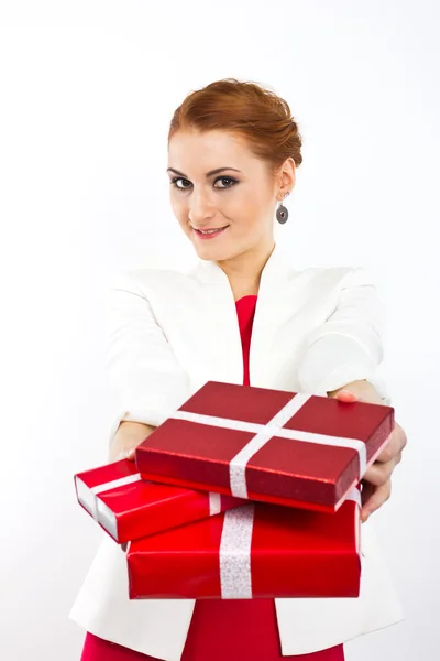 Девушка в красном платье с подарочной красной коробкой. Красивая рыжая девушка на белом . — стоковое фото