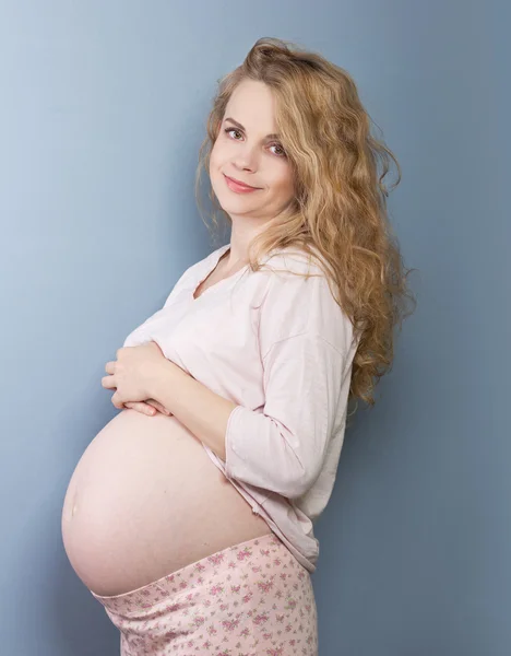 Hermosa rubia embarazada acariciando su vientre — Foto de Stock