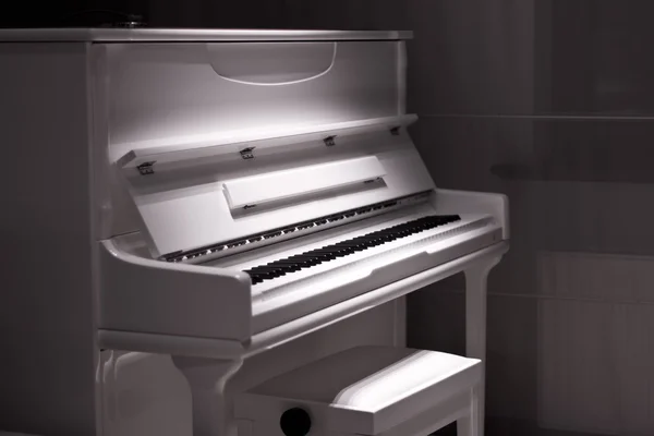 Biały fortepian w ciemności. Krzesło fortepian — Zdjęcie stockowe