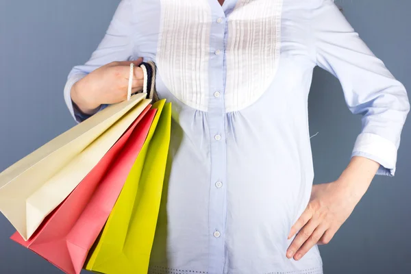 Joven mujer rubia embarazada en shopping.woman pareja retrato de compras. Bolsas de compras . —  Fotos de Stock