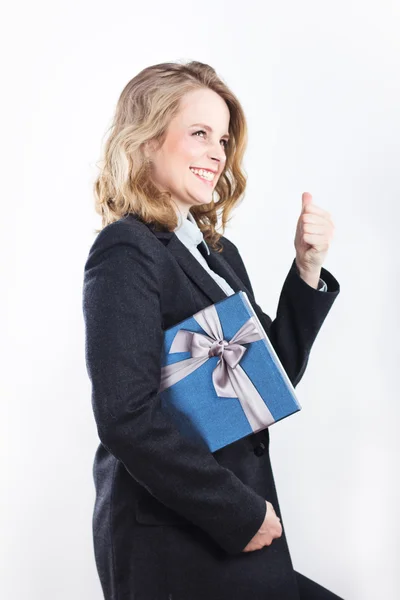 Mulher de negócios feliz com um presente. Retrato de uma loira em uma jaqueta em um branco — Fotografia de Stock