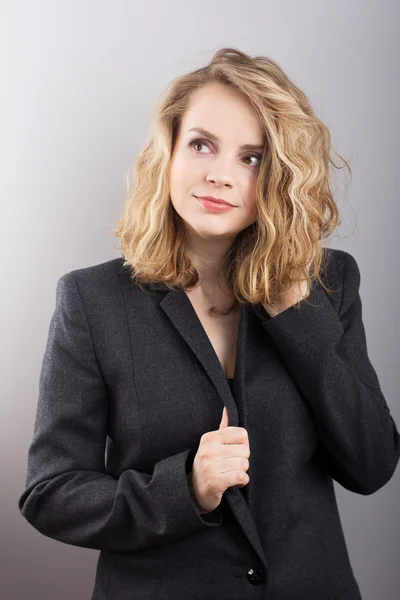 Beautiful business woman in a gray jacket. Beautiful blonde. Gray background. Business. Financier. — Stock Photo, Image