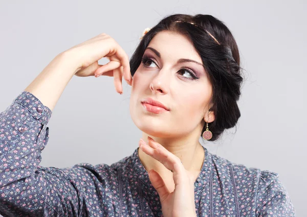 Beautiful brunette on a gray background. Girl cares for the skin.Hair style. Makeup. plump Lips — Stock Photo, Image