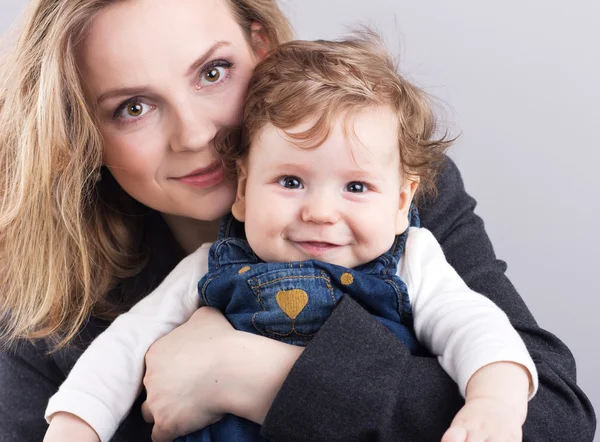 Young mother with a little boy in her arms. Portrait of mother and son. Beautiful blonde. pectoral baby. happy family — Stock Photo, Image