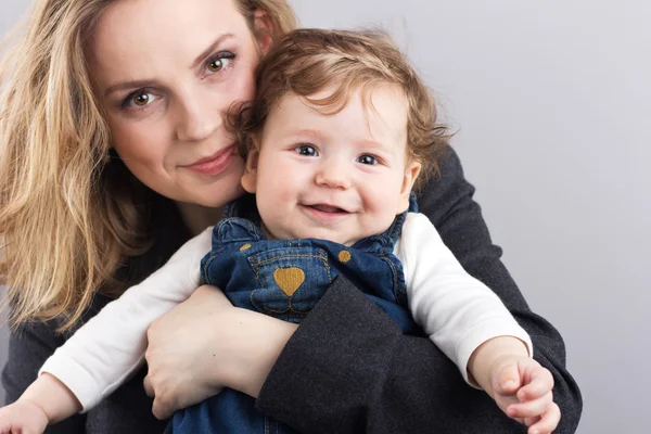 Young mother with a little boy in her arms. Portrait of mother and son. Beautiful blonde. pectoral baby. happy family — Stock Photo, Image