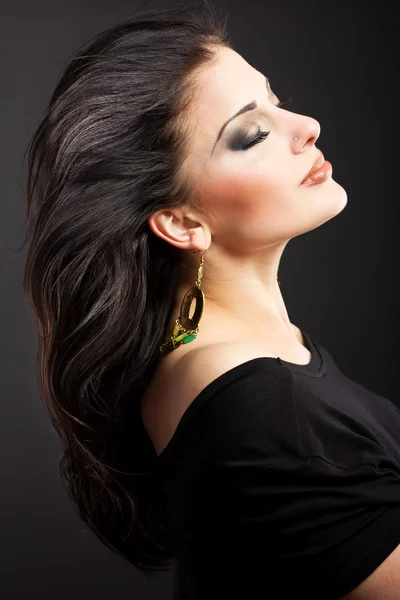 Burning brunette with flying hair on a black background — Stock Photo, Image