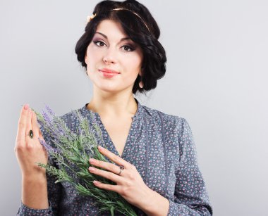 güzel esmer ile lavanta bir delikanlı. gri bir arka plan üzerinde genç bir kız portresi. Yunan saç kesimi ile esmer