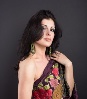 Siyah bir zemin üzerine parlak kıyafetleri çekici esmer. Moda portre. Güzel bir esmer portresi. Parlak işlemeli mendil