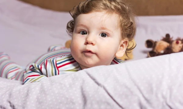 Bayi cantik dengan toys.The indah anak di tempat tidur — Stok Foto