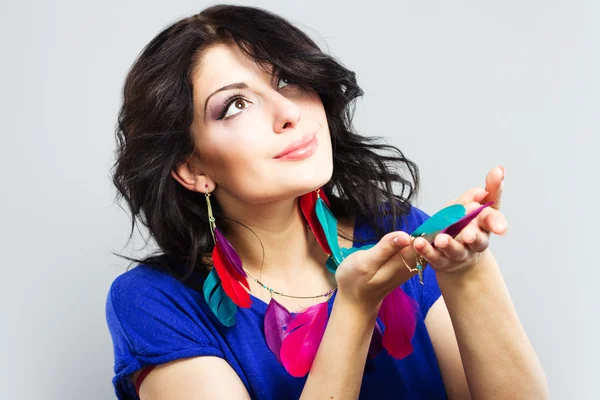 Chica joven con una camisa azul brillante. Retrato de una hermosa morena. Adornos hechos de plumas brillantes.Retrato facial de mujer sonriente . —  Fotos de Stock