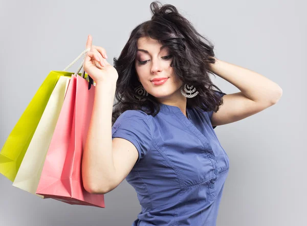 Hermosa morena con bolsas de compras.Retrato de una joven con nuevas compras —  Fotos de Stock