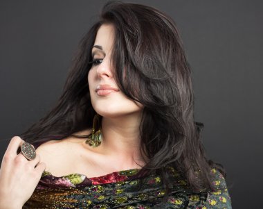 Siyah bir zemin üzerine parlak kıyafetleri çekici esmer. Moda portre. Güzel bir esmer portresi. Parlak işlemeli mendil