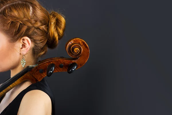 Une jeune fille joue du violoncelle dans le noir. Main sur le violoncelle — Photo