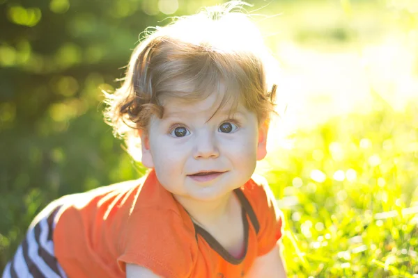 Schönes Kind, das im grünen Gras sitzt. Kind im Freien. Kinder gehen. Spaziergang mit dem Kind. Sommerferien — Stockfoto