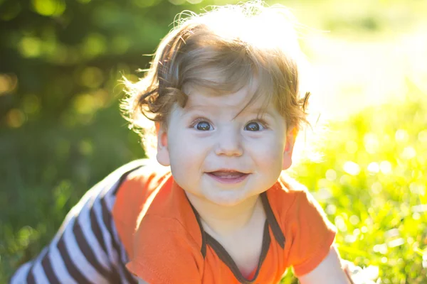 Schönes Kind, das im grünen Gras sitzt. Kind im Freien. Kinder gehen. Spaziergang mit dem Kind. Sommerferien — Stockfoto