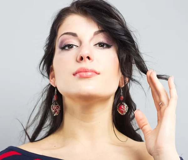 Beautiful brunette on a gray background — Stock Photo, Image