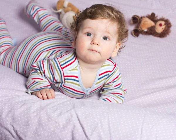 Beautiful baby with a lovely toy. The child in the crib. — Stock Photo, Image