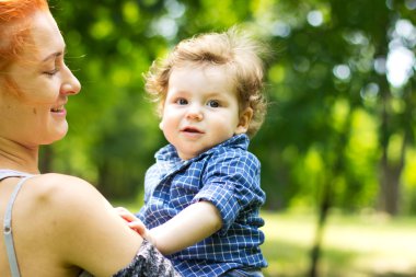 Young mother walking with a little boy. Child Outdoors.Mother and baby walk