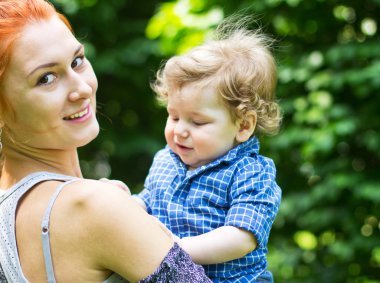 Young mother with a toddler. Beautiful girl with a child on a walk