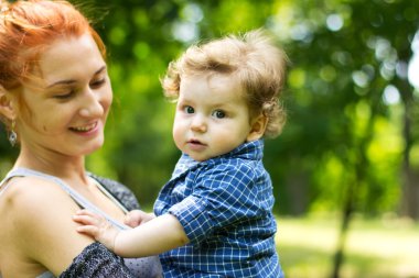 Young mother with a toddler. Beautiful girl with a child on a walk