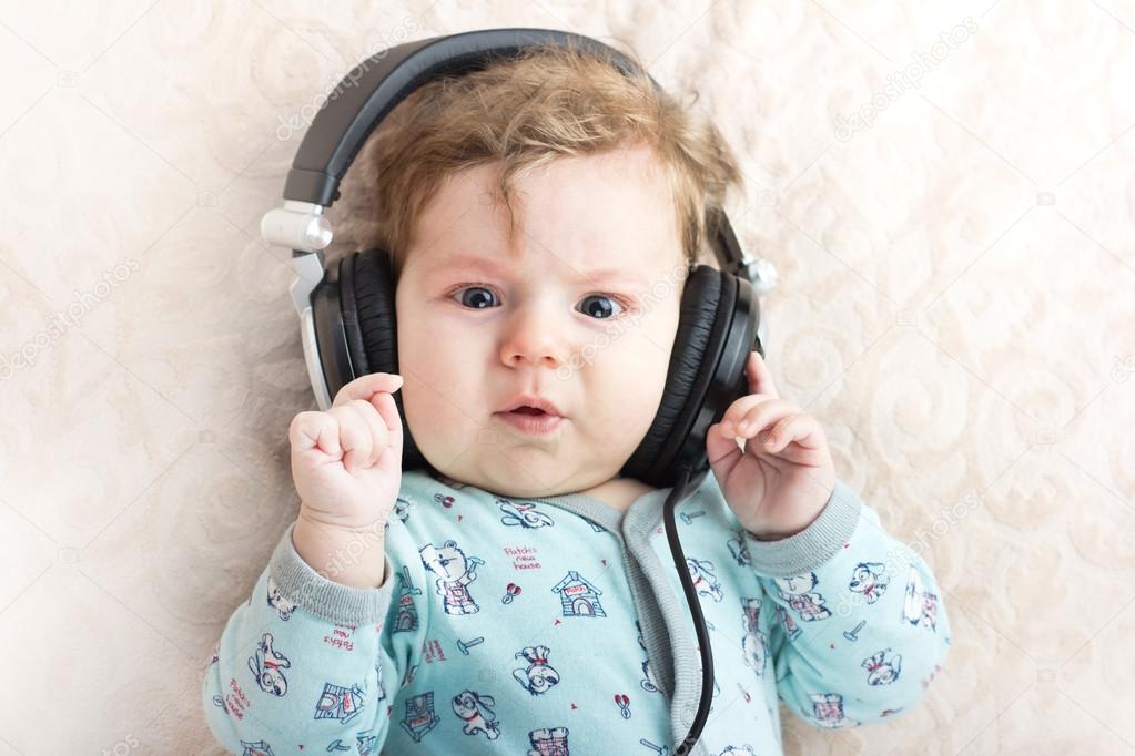 Funny baby in a big headphones. Portrait of a little boy. Cute child.