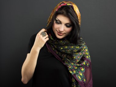 Siyah bir zemin üzerine parlak kıyafetleri çekici esmer. Moda portre. Güzel bir esmer portresi. Parlak işlemeli mendil