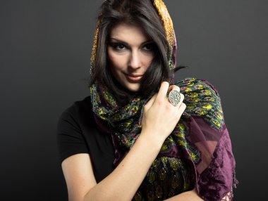 Siyah bir zemin üzerine parlak kıyafetleri çekici esmer. Moda portre. Güzel bir esmer portresi. Parlak işlemeli mendil