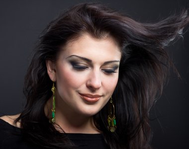 Güzel esmer ile uçan bir saç. Mücevher bir güzel kız portresi. Parlak saçlar. Moda. Güzel kadın süsler