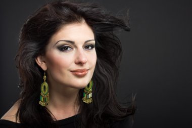 Güzel esmer ile uçan bir saç. Mücevher bir güzel kız portresi. Parlak saçlar. Moda. Güzel kadın süsler