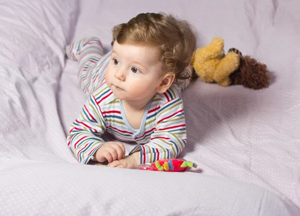 Beautiful baby with a lovely toy. The child in the crib. — Stock Photo, Image