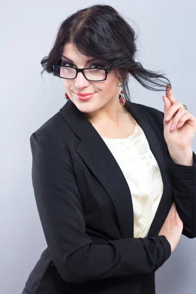 Mulher de negócios com um casaco preto estreito. Mulher de sucesso. Linda morena. Retrato de uma menina bonita em óculos — Fotografia de Stock