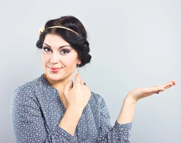 Beautiful brunette showing something or blank copyspase for product or sign text.beautiful girl with a gentle make-up — Stock Photo, Image