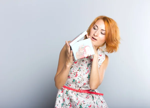 Una hermosa chica delgada con una caja de regalo en sus manos . — Foto de Stock