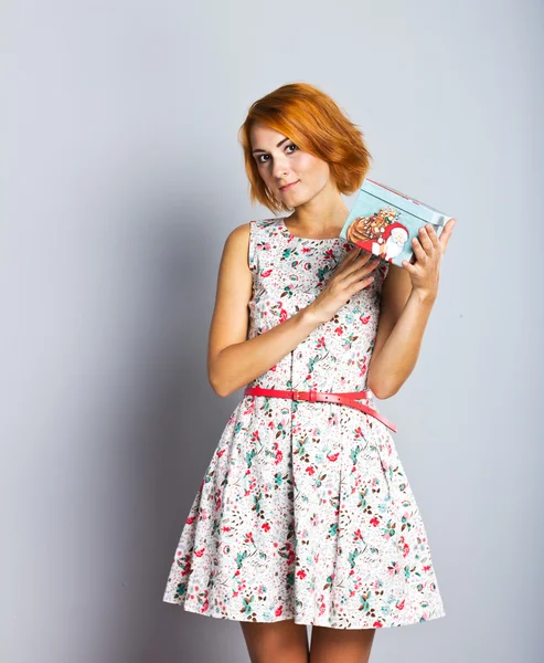 A beautiful slender girl with a gift box in her hands. — Stock Photo, Image