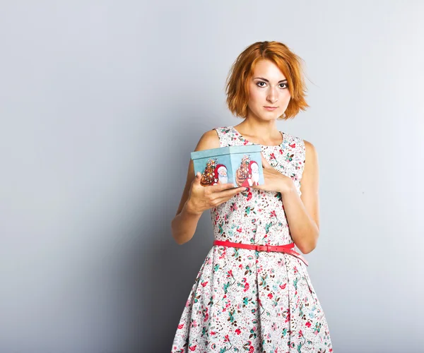 Una hermosa chica delgada con una caja de regalo en sus manos . —  Fotos de Stock