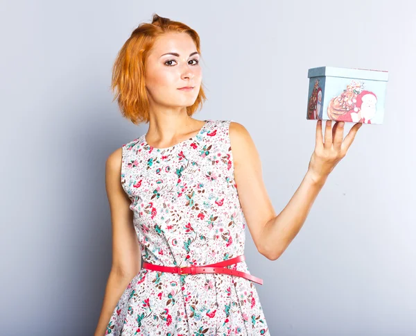 Una hermosa chica delgada con una caja de regalo en sus manos . —  Fotos de Stock