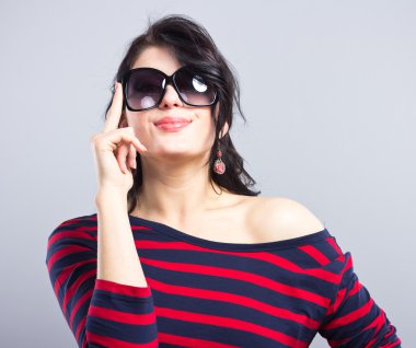 Güzel bir esmer portresi. Kadının yüzüne. Genç güzel kız. Güzel esmer kırmızı çizgili mavi bir elbise içinde. Moda