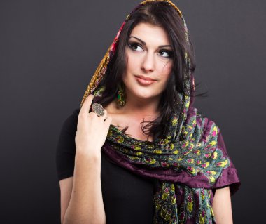 Siyah bir zemin üzerine parlak kıyafetleri çekici esmer. Moda portre.