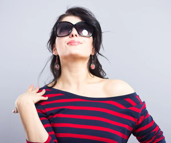 Portret van een mooie brunette. Vrouw gezicht. Mooi meisje. Mooie brunette in een blauwe jurk met rode strepen. Mode — Stockfoto