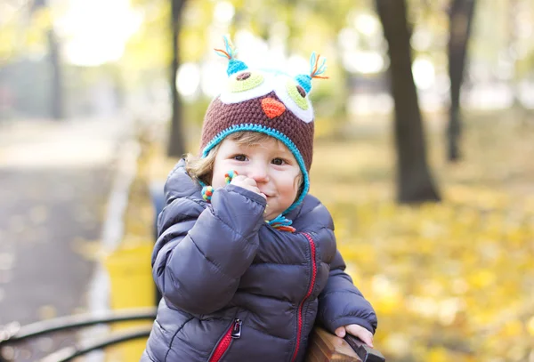 Niedliches Baby mit lustigem Hut auf einem Spaziergang. Herbstpromenade. Kopfbedeckung. eine Mütze — Stockfoto