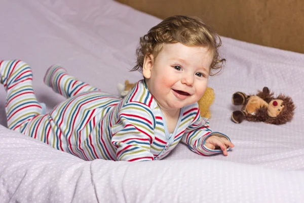 Beautiful baby with a lovely toy. The child in the crib. — Stock Photo, Image