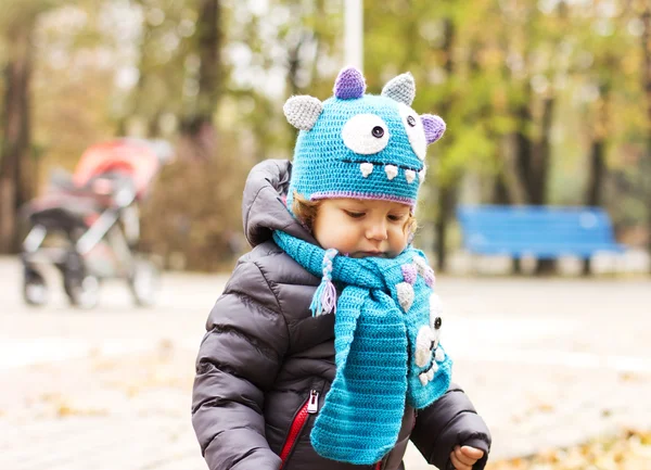 Happy baby i en rolig hatt på en promenad. Gångavstånd utomhus på hösten. Höstlöv — Stockfoto