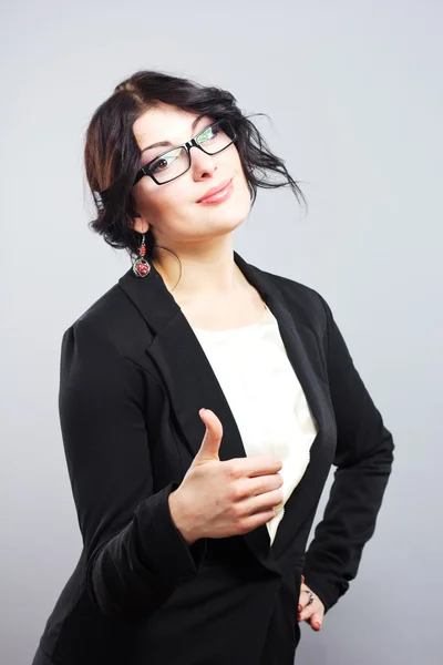 Atractiva morena con gafas que muestran el pulgar.Mujer de negocios sonriente en un traje estricto. hermosa mujer de negocios en gafas que muestran el pulgar hacia arriba símbolo . —  Fotos de Stock