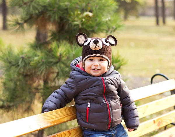 Happy baby i en rolig hatt på en promenad. Gångavstånd utomhus på hösten. Höstlöv — Stockfoto