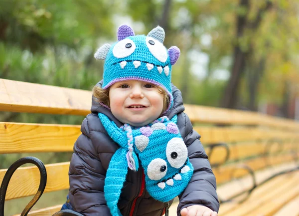 Happy baby i en rolig hatt på en promenad. Gångavstånd utomhus på hösten. Höstlöv — Stockfoto