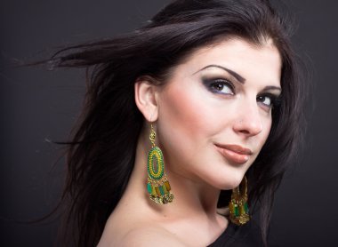 Güzel esmer ile uçan bir saç. Mücevher bir güzel kız portresi. Parlak saçlar. Moda. Güzel kadın süsler