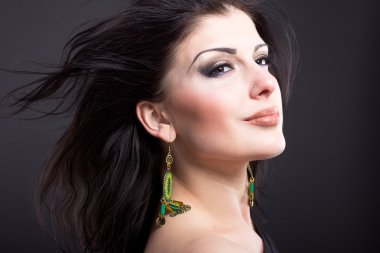 Güzel esmer ile uçan bir saç. Mücevher bir güzel kız portresi. Parlak saçlar. Moda. Güzel kadın süsler