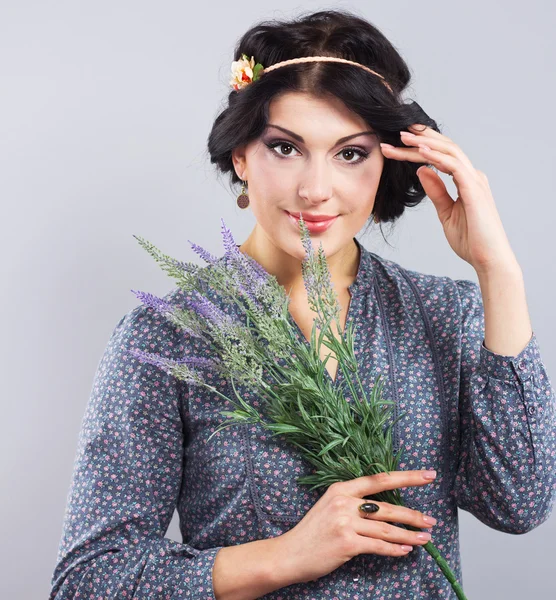 Hermosa morena con un arbusto de lavanda. Retrato de una mujer bien arreglada —  Fotos de Stock